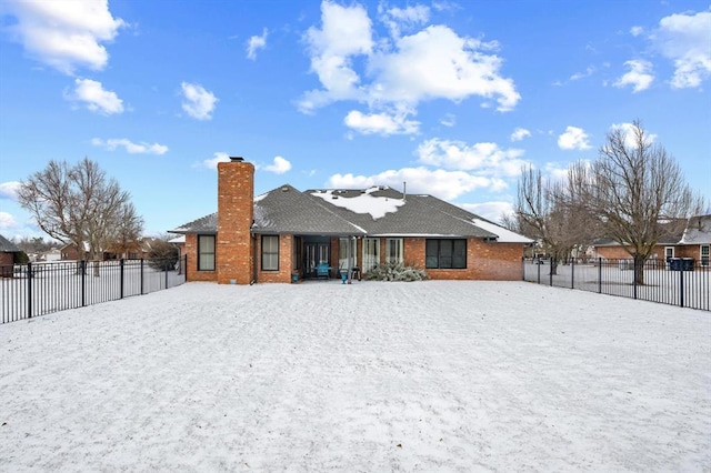 rear view of property featuring a chimney, fence, and brick siding