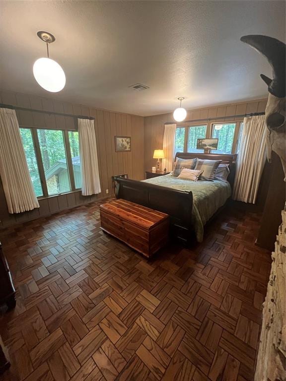 bedroom featuring multiple windows and dark parquet flooring