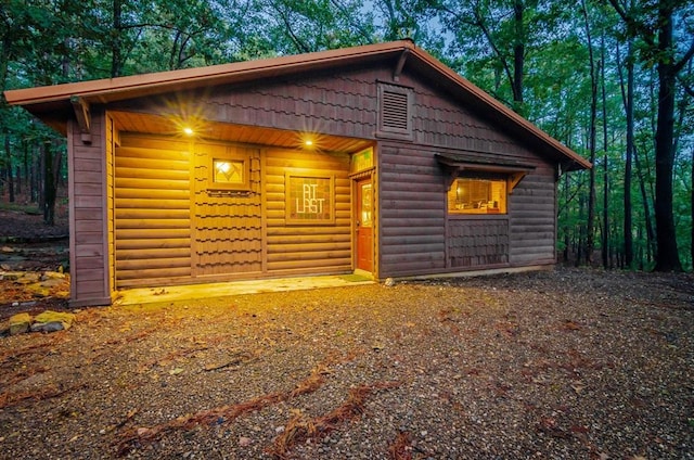 view of side of property with an outbuilding and log veneer siding