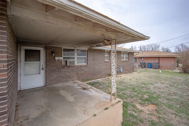 view of patio featuring an attached carport, cooling unit, and fence