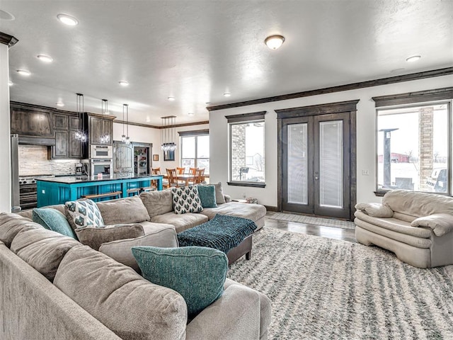 912 Ash NE, Piedmont, OK 73078 - living room featuring light wood-style flooring, recessed lighting, baseboards, french doors, and ornamental molding