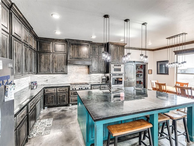 912 Ash NE, Piedmont, OK 73078 - kitchen featuring pendant lighting, a center island with sink, decorative backsplash, dark brown cabinetry, and premium range hood