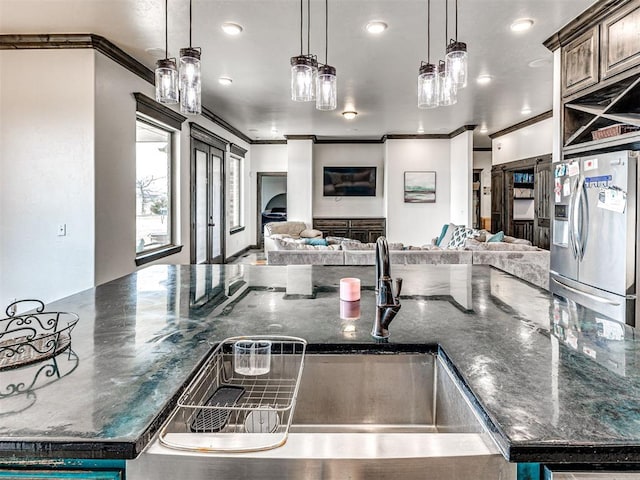 912 Ash NE, Piedmont, OK 73078 - kitchen featuring open floor plan, hanging light fixtures, crown molding, stainless steel refrigerator with ice dispenser, and a sink
