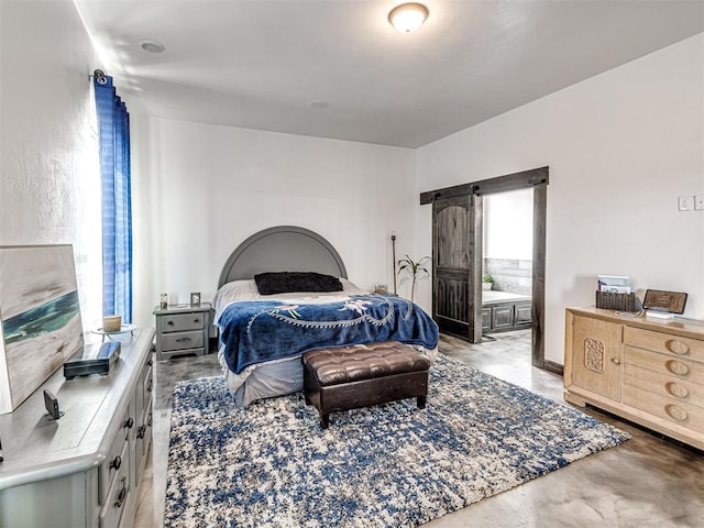 912 Ash NE, Piedmont, OK 73078 - bedroom with a barn door and concrete floors