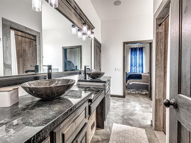 912 Ash NE, Piedmont, OK 73078 - ensuite bathroom featuring double vanity, a sink, ensuite bath, concrete floors, and baseboards