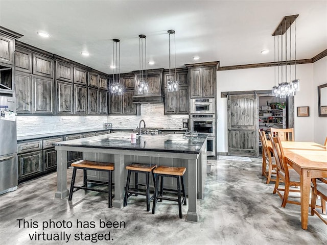 912 Ash NE, Piedmont, OK 73078 - kitchen featuring hanging light fixtures, dark brown cabinets, an island with sink, and custom range hood