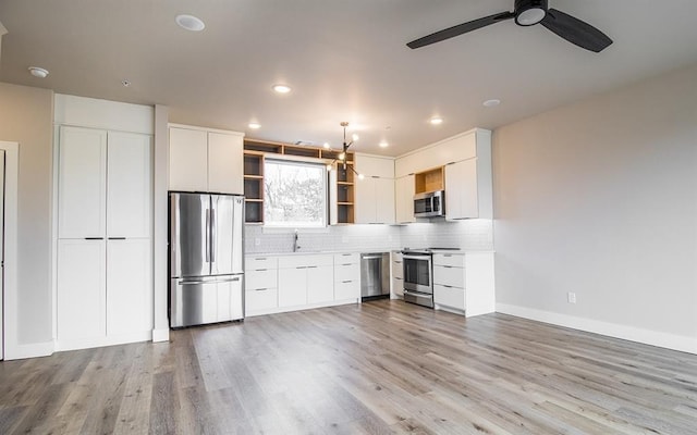 kitchen with decorative backsplash, stainless steel appliances, and white cabinets