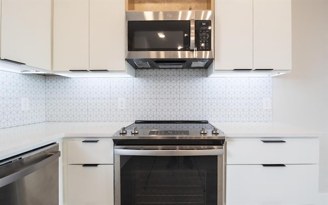 kitchen with white cabinetry, stainless steel appliances, and decorative backsplash