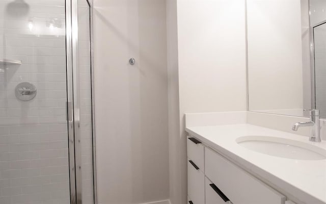 bathroom with a shower with shower door and vanity