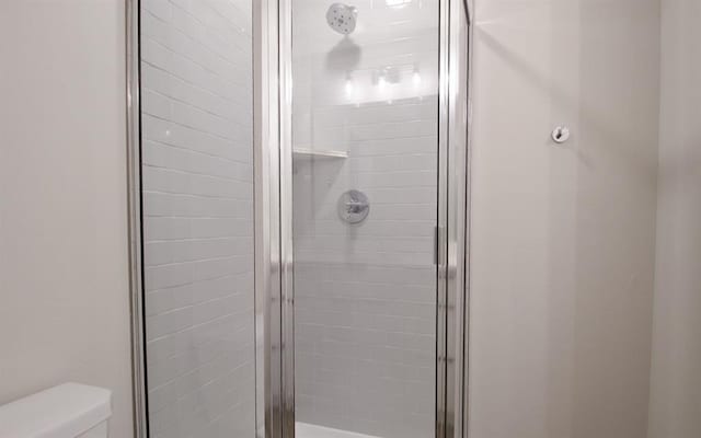 bathroom featuring toilet and an enclosed shower