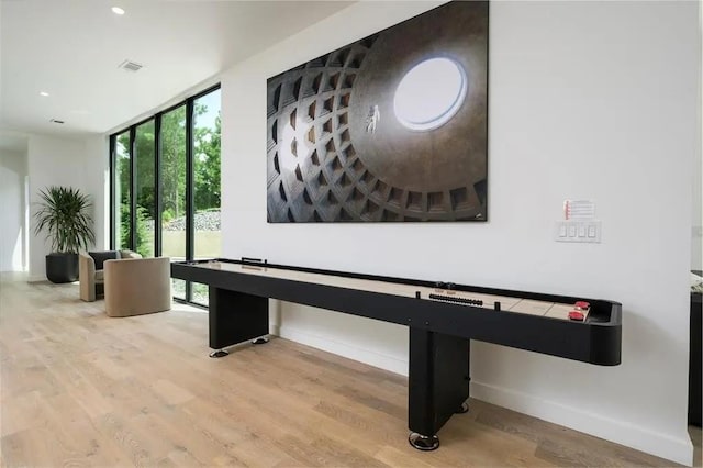 recreation room with floor to ceiling windows, recessed lighting, visible vents, light wood-type flooring, and baseboards