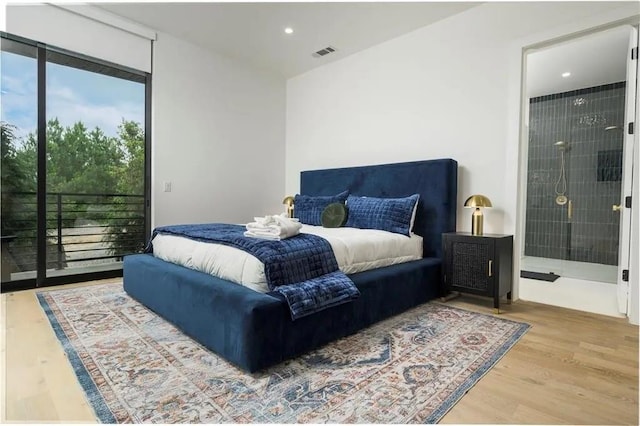 bedroom featuring access to exterior, connected bathroom, visible vents, and wood finished floors