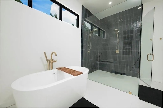 bathroom with a freestanding tub and a tile shower