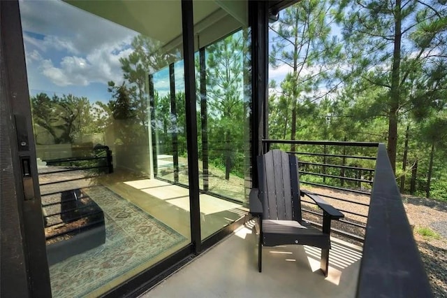 exterior space with finished concrete flooring, a healthy amount of sunlight, and a wall of windows