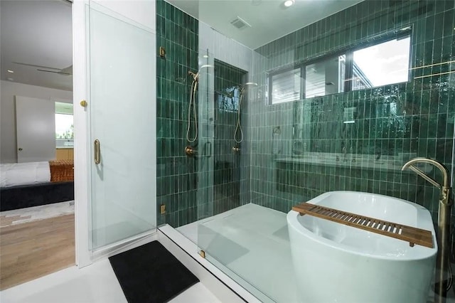 ensuite bathroom with a tub, a stall shower, tile walls, and ensuite bathroom