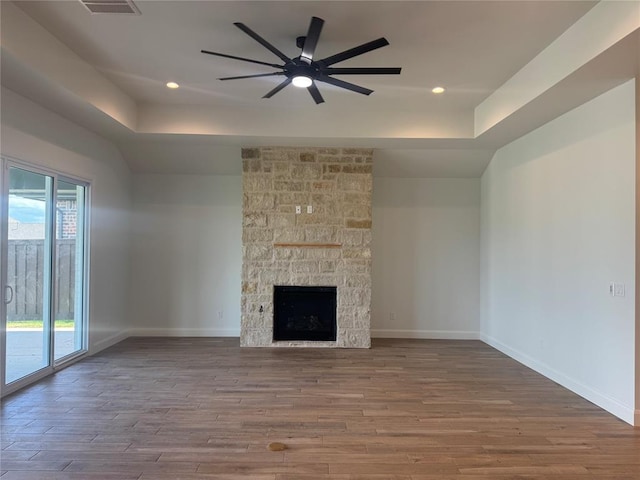 12804 Cobblestone Curve Rd, Oklahoma City, OK 73142 - unfurnished living room with a tray ceiling, wood finished floors, a ceiling fan, recessed lighting, and a fireplace