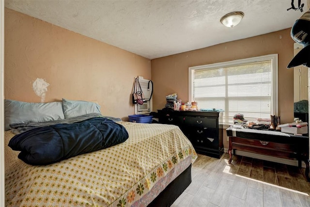 bedroom featuring a textured ceiling and light wood-type flooring