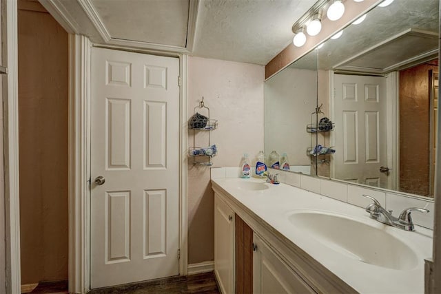 bathroom featuring wood finished floors, a sink, and double vanity