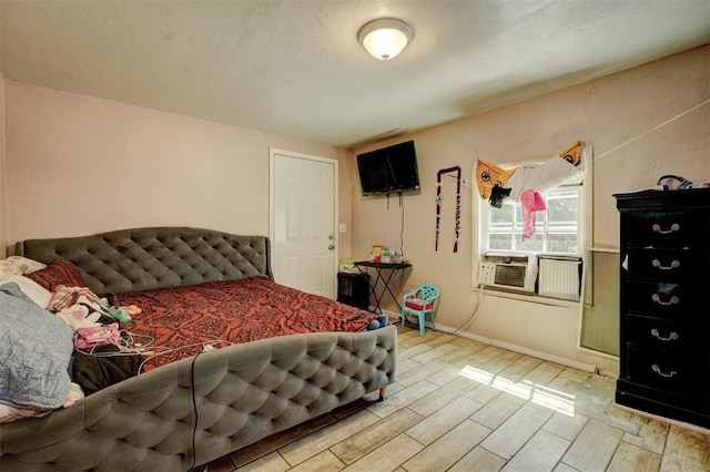 bedroom featuring baseboards and wood tiled floor