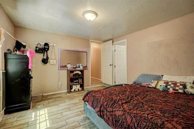 bedroom with baseboards and wood finish floors