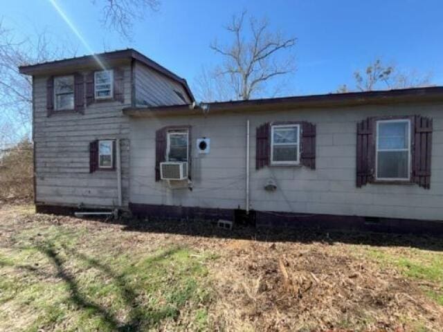 view of side of property featuring cooling unit and a lawn