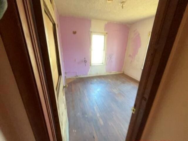 unfurnished bedroom with hardwood / wood-style flooring and a textured ceiling