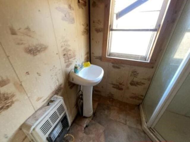 bathroom featuring heating unit and walk in shower