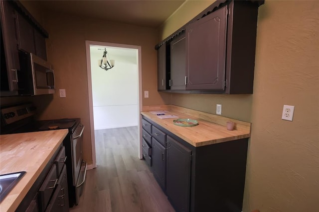 3805 SE 26th St, Del City, OK 73115 - kitchen with wooden counters, stainless steel appliances, dark wood finished floors, and a chandelier
