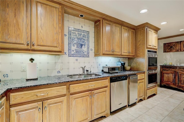 kitchen featuring light tile patterned floors, stainless steel appliances, backsplash, a sink, and dark stone counters