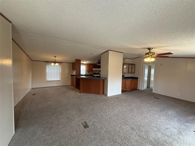 unfurnished living room featuring a textured ceiling, ceiling fan, and light colored carpet