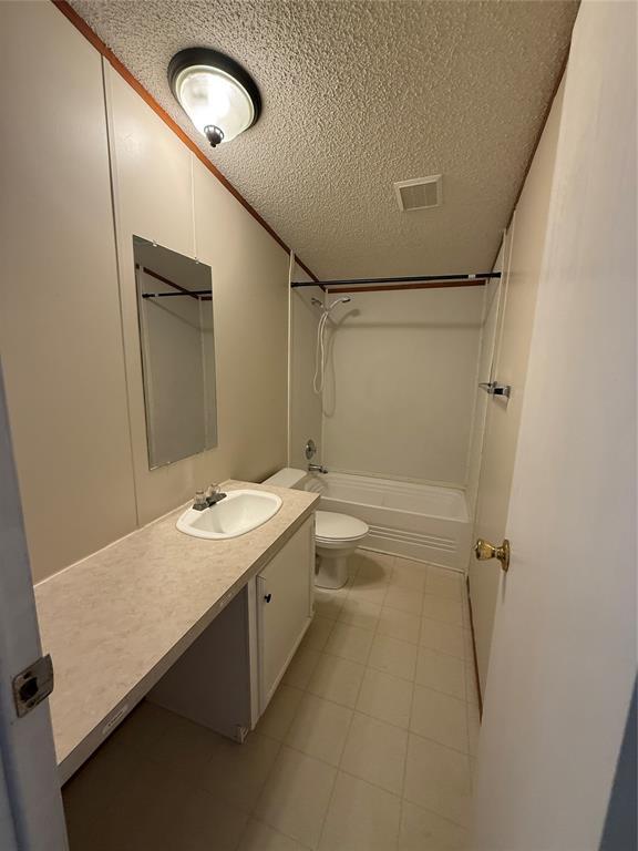 full bathroom with vaulted ceiling, shower / bathtub combination, vanity, a textured ceiling, and toilet