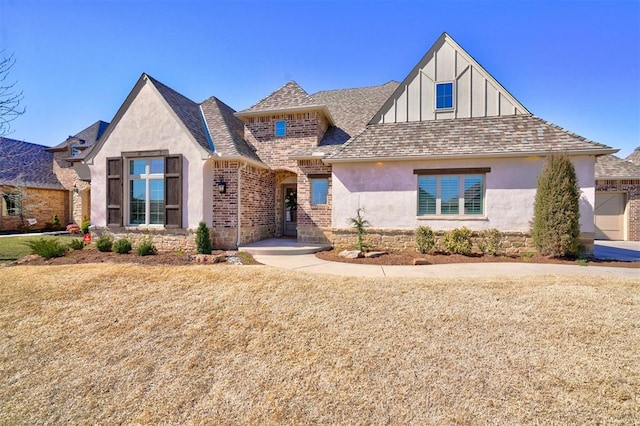 view of front of property with a shingled roof, brick siding, and stucco siding