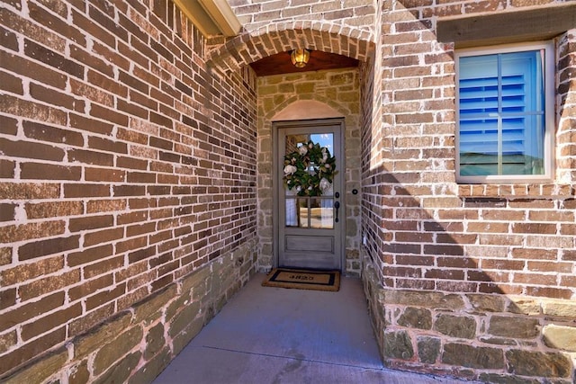 doorway to property with brick siding