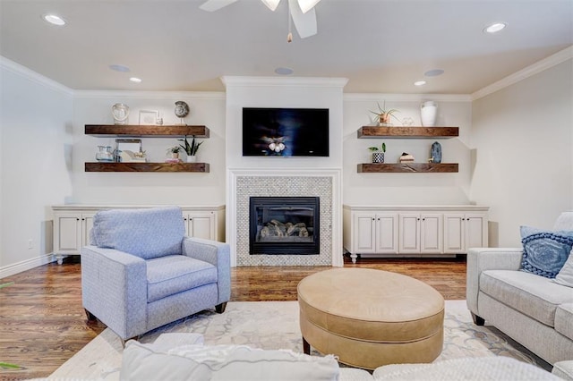 living room with a fireplace, recessed lighting, ornamental molding, wood finished floors, and baseboards