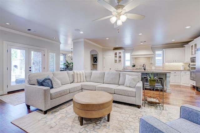 living area featuring visible vents, light wood-style flooring, ornamental molding, french doors, and recessed lighting