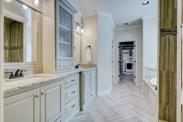 full bathroom with double vanity, washer / dryer, ornamental molding, a spacious closet, and a sink