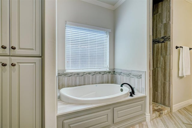 full bath with ornamental molding, a garden tub, and a tile shower