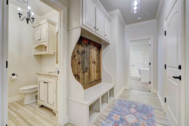 mudroom featuring an inviting chandelier, baseboards, and ornamental molding