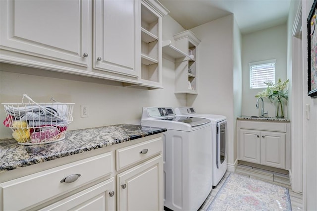 washroom featuring a sink, cabinet space, and washer and dryer