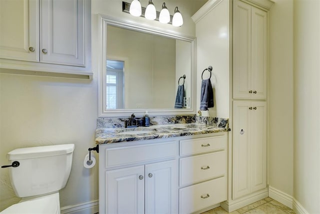 bathroom with tile patterned flooring, vanity, toilet, and baseboards