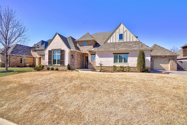 view of front of house featuring a garage, brick siding, a shingled roof, and stucco siding