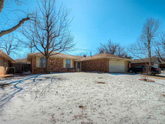 ranch-style home with a garage, brick siding, and fence