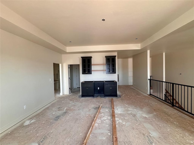 interior space featuring baseboards and a raised ceiling