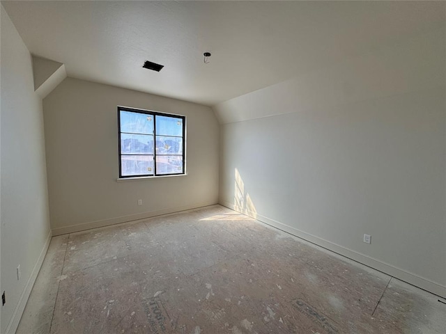 unfurnished room featuring lofted ceiling