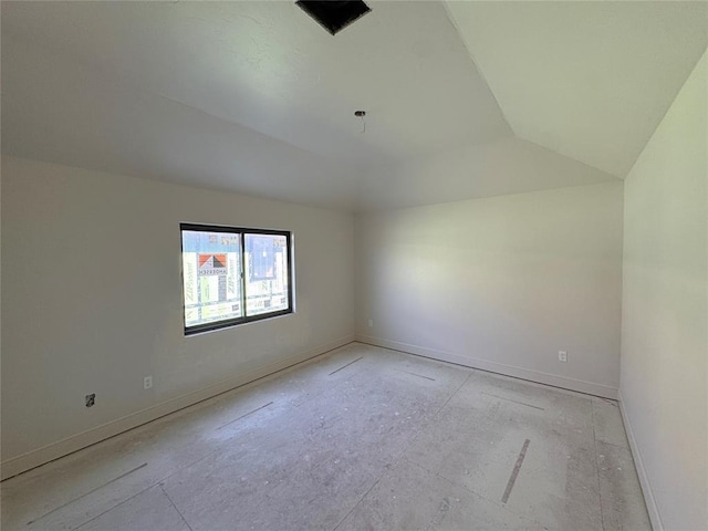 empty room with lofted ceiling and baseboards