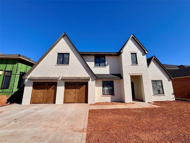 view of front of property with a garage, brick siding, and driveway