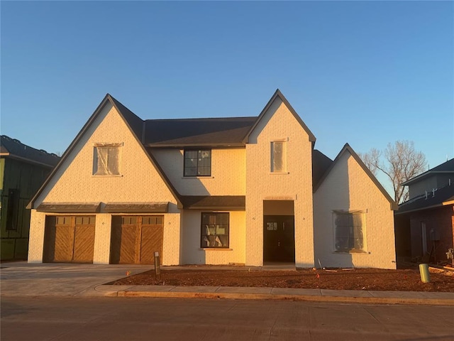 view of front facade featuring a garage, concrete driveway, and brick siding