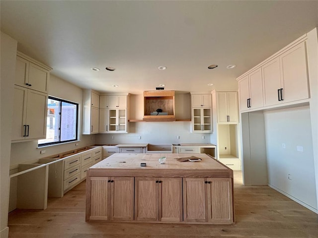 kitchen featuring recessed lighting, white cabinets, a center island, open shelves, and light wood finished floors