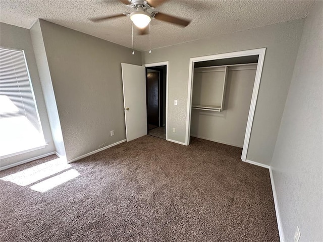 unfurnished bedroom featuring ceiling fan, carpet, a textured wall, a closet, and a textured ceiling