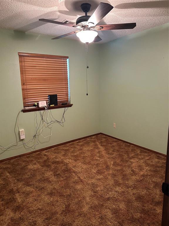 empty room with carpet floors, a textured ceiling, and ceiling fan